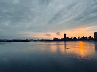 Naklejka premium Sunset with reflection in a cloudy day