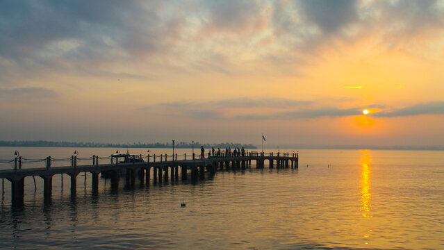 Golden sunset over the ocean with a long pier - Powered by Adobe