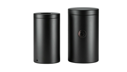 Two dark cylindrical objects, one with a small dot, against a solid black background with dramatic lighting