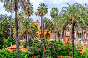 Royal Alcazar of Seville, Spain, gardens, palm trees and architectural elements of the palace