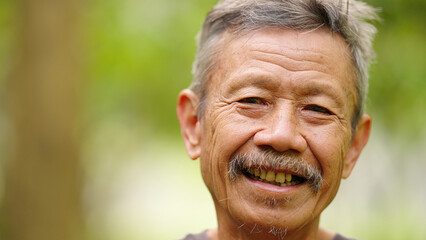 closeup face portrait, smiling indonesian man farmer in rural indonesia, ageing or aging farming population, southeast asia, grey hair and wrinkles © Spice Footage