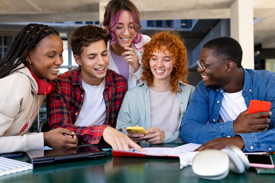 Group of cheerful diverse students working together on a project at university campus