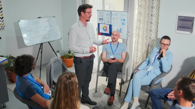 A corporate psychologist conducts a professional training session with employees seated in a circle, discussing teamwork, communication, and emotional growth in a modern office setting.