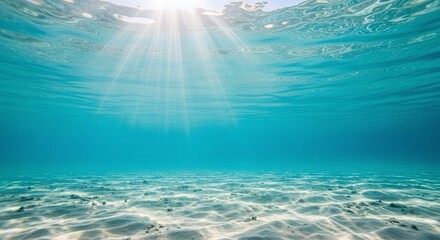 Underwater view, sun rays, clear blue ocean, sandy sea floor