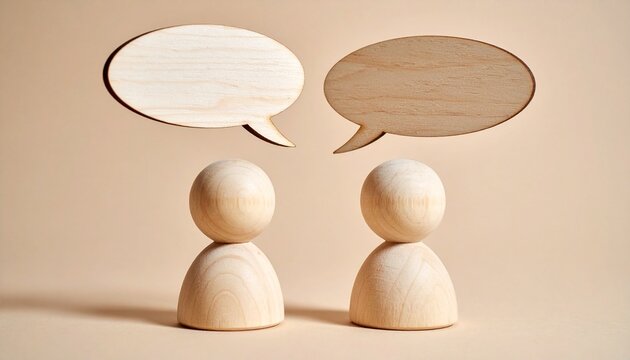 Two wooden figurines with speech bubbles on beige surface.