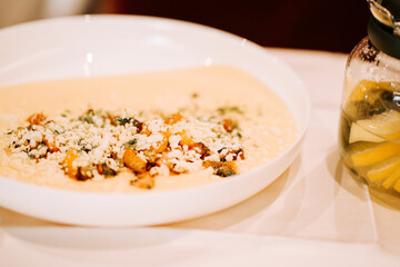 Freshly prepared dish featuring cheese and spices served with a refreshing drink