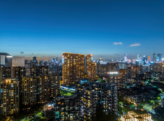 Naklejka premium Dense urban residential and commercial district illuminated with bright lights at night in Shenzhen.