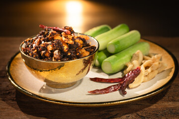 Pork Crackling Chili Paste (Nam Phrik kak Moo): Crispy, spicy, and savory. This Thai relish features crunchy cracklings, chili, and herbs. Served with fresh cucumber. A perfect crunch with hot rice.