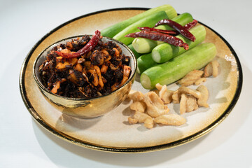 Pork Crackling Chili Paste (Nam Phrik kak Moo): Crispy, spicy, and savory. This Thai relish features crunchy cracklings, chili, and herbs. Served with fresh cucumber. A perfect crunch with hot rice.