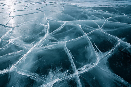Deep cracks in thick, transparent lake ice forming mesmerizing patterns