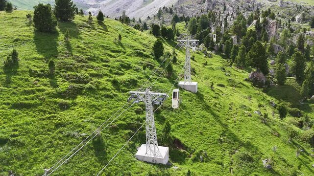 14 july 2024, Italy. Forward drone flight at sassolungo cable car, telecabin force del sassolungo, coffin lift, during summer. Sassolungo mountain in the background. Vintage cable car from the 60's. D