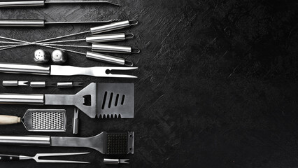 Steel barbecue and grill set. On a black slate table. Top view.