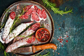 slices of traditional Spanish salami in a plate. dry sausage covered fermented mold. On a stone background. Top view.