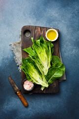 Preparing a salad with Romaine Lettuce. Green organic food. Top view. On a gray concrete background.
