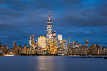Twilight view of Lower Manhattan skyline with World Trade Center illuminated skyscrapers. Scenic New York City waterfront and Financial District at dusk, USA