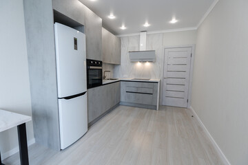 Brand new fitted kitchen with white cabinet and fully marble tiled walls