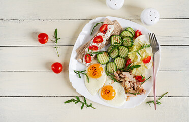 Ketogenic, paleo diet. Fried eggs, boiled chicken and fresh salad. Keto breakfast. Brunch. Top view
