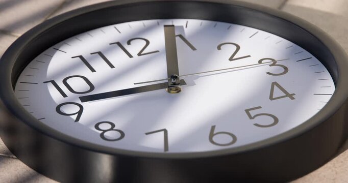 Sun and sky reflecting in the watch during the time passing by. Time lapse on a modern white Clock on black. Close up to a wall clock, with running time pointer. Wall clock show the running time