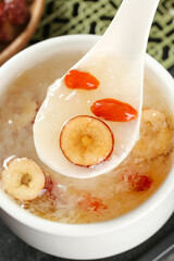 Sweet Chinese Dessert Soup with Red Dates and Silver Ear Fungus in White Ceramic Spoon
