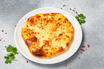 Georgian khachapuri with cheese. Pizza with cheese. On a stone background.