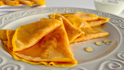 A close-up of crepes drizzled with honey