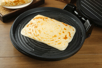 Making Homemade Flapjack Pastry with Ham and Egg Filling on Grill Pan