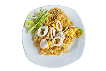 Thai-style stir-fried noodles with squid, tofu, egg, bean sprouts, and crushed peanuts, served with lime and chives on a white plate. Traditional Thai street food known for its balance of sweet, sour,