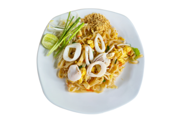 Thai-style stir-fried noodles with squid, tofu, egg, bean sprouts, and crushed peanuts, served with lime and chives on a white plate. Traditional Thai street food known for its balance of sweet, sour,