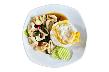 Thai traditional dish of stir-fried squid with basil leaves, chili, and garlic, served with jasmine rice and fried egg on a white plate.