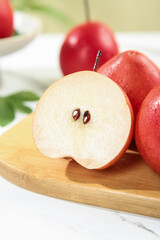Fresh Red Pears Cut in Half on Wooden Board Showing Seeds and Flesh