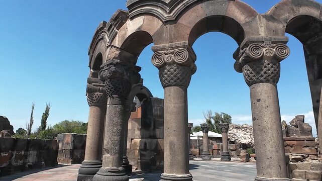 Ancient columns of Zvartnots Cathedral ruins, UNESCO site in Armenia. Horizontal shot focused on 7th century historical architecture. No people, highlighting the stone textures and peaceful landscape