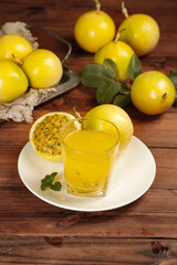 Fototapeta premium Fresh Golden Passion Fruit Juice with Whole Fruits on Rustic Wood Table