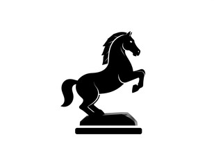 Black silhouette of a rearing horse statue set on a blocky pedestal on white