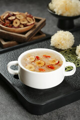 Asian soup with red dates and fungus in white bowl with traditional ingredients and mushroom garnishes