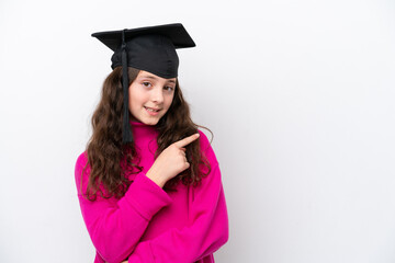 Little student girl wearing a graduated hat isolated on pink background pointing to the side to present a product