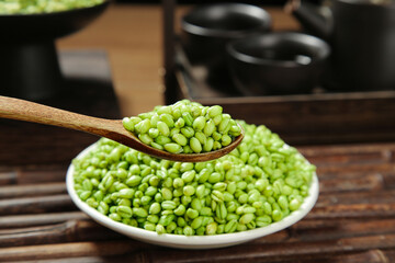 Fresh Green Mung Bean Kernels in Bowl with Wooden Spoon on Kitchen Table