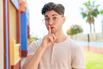 Young handsome man With glasses and doing silence gesture