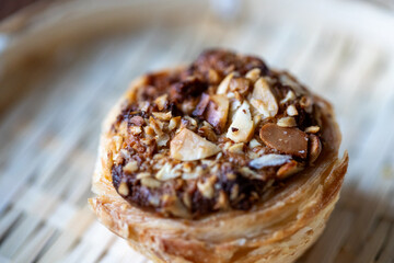 Close-Up of Traditional Portuguese Pistachio Nata Dessert in a Wicker Plate on a Brown Table

