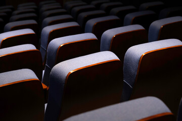 Fototapeta premium Karachi, Pakistan - April 10, 2025: A captivating view of multiple rows of empty seats under dim lighting, Ideal for concepts related to education, presentations, cinema, events, or public gatherings.