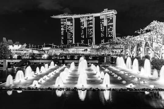 Singapore, Asia: Twilight view of Singapore waterfront skyline with colorful artesian fountains in black and white