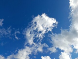 White Cotton Clouds Dancing in the Clear Blue Sky on a Sunny Day