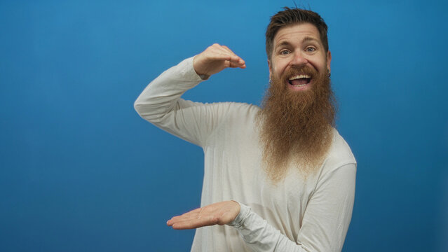 Man with long beard holds invisible object gesture with palms in blue studio; playfulness demonstration. - Powered by Adobe