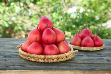 Fresh Red Pears from Shaanxi China in Wicker Baskets on Wooden Table with Natural Background