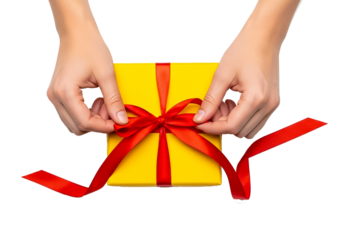 Close-up of hands tying a red bow on a gift box