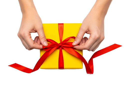 Close-up of hands tying a red bow on a gift box