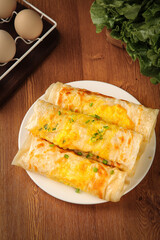 Savory Egg Pancake Wraps with Ham and Scallions on Wooden Table