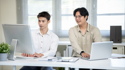 Two male office workers are discussing work in the office.