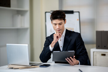 A businessman is discussing work with a client at a desk in an office.