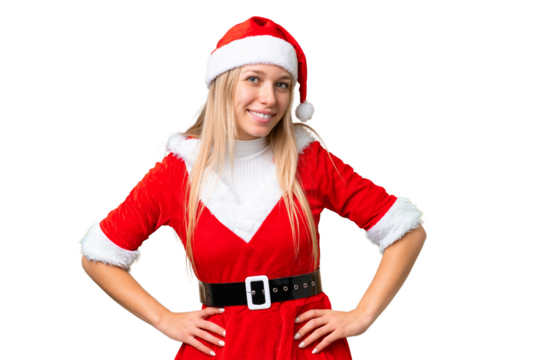 Young blonde woman with christmas hat over isolated chroma key background posing with arms at hip and smiling