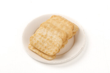 Japanese Senbei Rice Crackers on White Plate - Traditional Puffed Biscuits and Asian Snacks